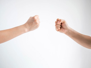 Two person playing rock paper scissors with both posturing rock or hammer symbol on white background.