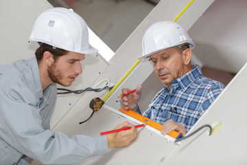 two workers using spirit level on window opening