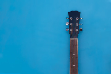 acoustic guitar on lying on blue wall close up