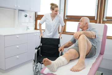 nurse helping a recovering patient to his wheelchair