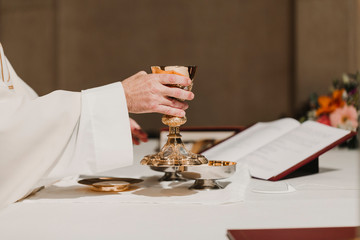 unrecognizable Priest holding the goblet during a wedding ceremony nuptial mass. Religion concept