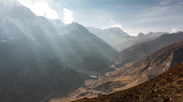 Timelapse of Himalayas mountains with light rays between clouds in Annapurna Circuit Trek seeing Manang and Tilicho peak in the background