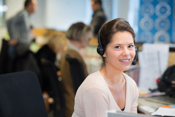 smiling female customer service agent wearing headset