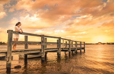 Young woman taking a peaceful moment to relax and watch the sunset.