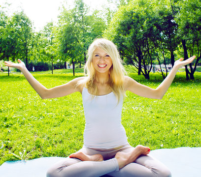 blonde real girl doing yoga in green park, lifestyle sport people concept