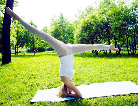 blonde real girl doing yoga in green park, lifestyle sport people concept