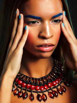 young pretty modern african american girl with bright fashion makeup and ethnic jewelry closeup