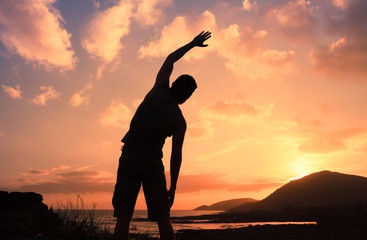 Body health and balance, man exercising at sunrise outdoors. 