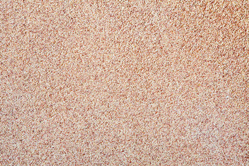 Against the background of disseminated sand small gravel, a stone crumb. Texture of a surface of a wall,light color