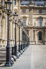 Architectural landscape of the alleys and lamps of the Place des Pyramides of the Louvre Museum in Paris - Paris, France