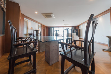Wooden chairs at table in bright open space interior 