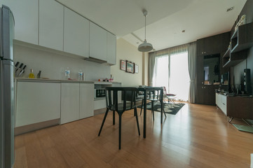 Wooden chairs at table in bright open space interior 