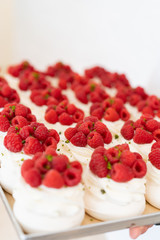 Super fresh pavlova dessert made from whipped egg whites with fresh raspberries and pistachios. Sugar meringue.