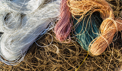 ravels of pastel (brown, white, pink, green and orange) color raphia ropes background