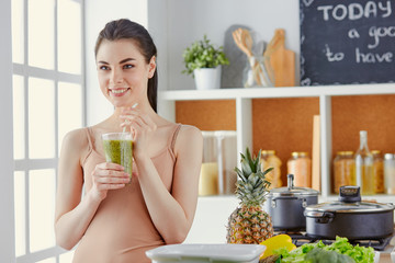 a young girl drinks a cocktail on a kitchen