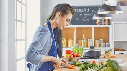 A young woman prepares food in the kitchen. Healthy food - vegetable salad. Diet. The concept of diet. Healthy lifestyle. Cook at home. Cook