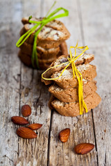 Fresh Italian cookies cantuccini stackes and almond nuts on ructic wooden table background.