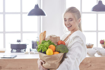 Young woman holding grocery shopping bag with vegetables Standi