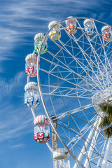 Colourful Ferris Wheel in the amusement park. Ferris Wheel with blue background. Funfair.
