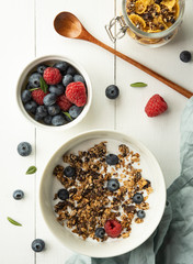 breakfast granola with milk blueberry raspberry cornflakes top view wood background