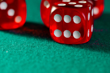 Close-up of several red dice with different digital combinations on green cloth in a casino