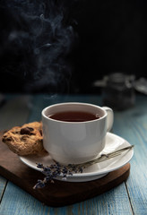 White cup of tea with water stream cookies handmade close up gray