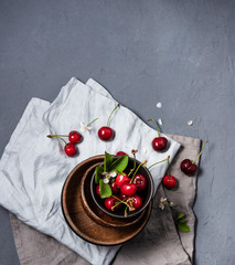 cherry berry on wood  bowl with flowers on gray table and napkins  top view summer morning shaddow window vegan