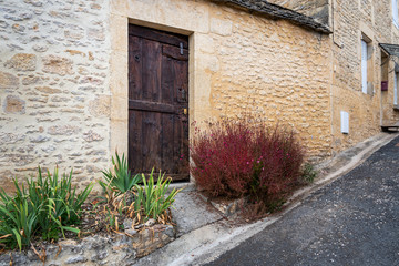 Rustic brown wooden door of an old stone house