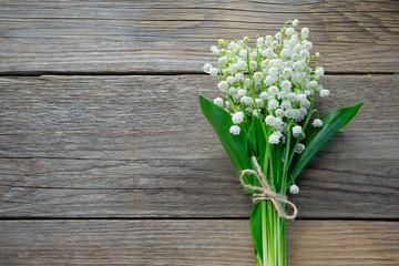 Lilies of the valley on wooden background. Top view.