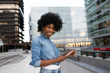 attractive dark skinned girl is listening to music chatting with friends smiling booking tickets online banking