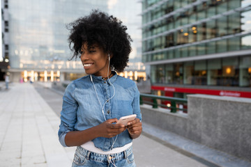 attractive dark skinned girl is listening to music chatting with friends smiling booking tickets online banking