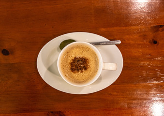 Cappuccino coffee on dark wood table 