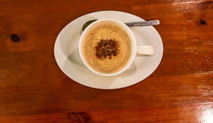 Cappuccino coffee on dark wood table 