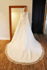 Fototapeta na wymiar A beautiful wedding dress hangs on a mirror