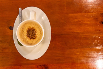 Cappuccino coffee on dark wood table 