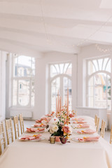 Wedding decoration table in the hall, floral arrangement. In the style vintage. Decorated dining table with flowers for guests and newlyweds, in peach-pink & pastel color. Beautiful table setting.