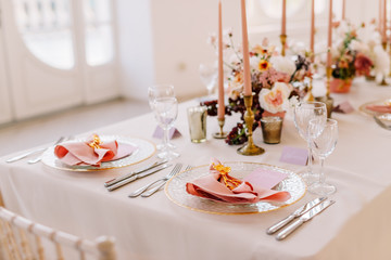 Wedding decoration table in the hall, floral arrangement. In the style vintage. Decorated dining table with flowers for guests and newlyweds, in peach-pink & pastel color. Beautiful table setting.