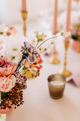 Wedding decoration table in the hall, floral arrangement. In the style vintage. Decorated dining table with flowers for guests and newlyweds, in peach-pink & pastel color. Beautiful table setting.