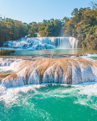 Couple contemplating the majestic turquoise waterfalls at Agua Azul in Chiapas, Mexico