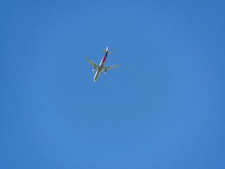Air plane flying destination on the clear blue sky when summer season