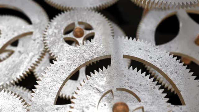 the camera moves along the rotating gears and focuses on the inscription AUTOCRACY on the gear