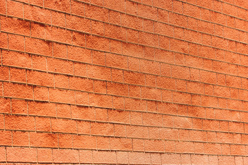 Closeup perspective view of old red brick wall in sunlight for background.