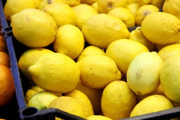 lots of yellow lemons in the box, background. Good harvest citrus