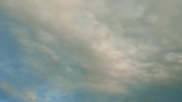 Intense movement of white and gray clouds across the blue sky, timelapse
