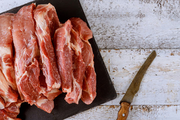 Uncooked pork chops on a wooden board