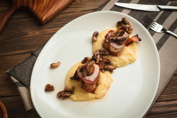 Pork neck with mushrooms and mashed potatoes. Cafe menu on a wooden background in warm colors with copy space.