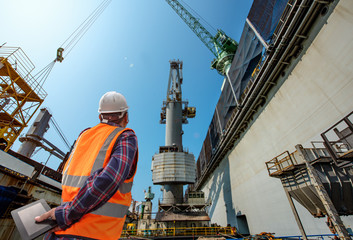 stevedore or foreman, engineering, loading master talks to crane driver by walkie talkie for safety...