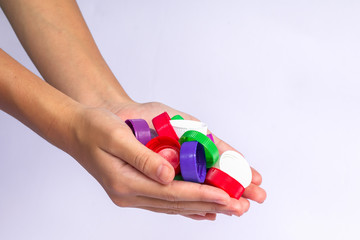 Girls holding plastic bottles caps for recycling to conserve the environment, on white background