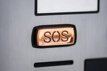  button SOS.  SOS button close-up on the device panel, intercom. Help call button on the screen of the device in gray metal color.