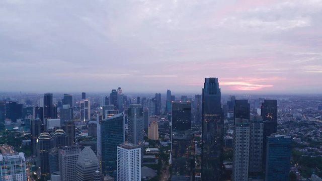 JAKARTA, Indonesia - May 23, 2019: Aerial view of silhouette of modern skyscrapers in Jakarta financial district at sunrise. Shot in 4k resolution from a drone flying upwards